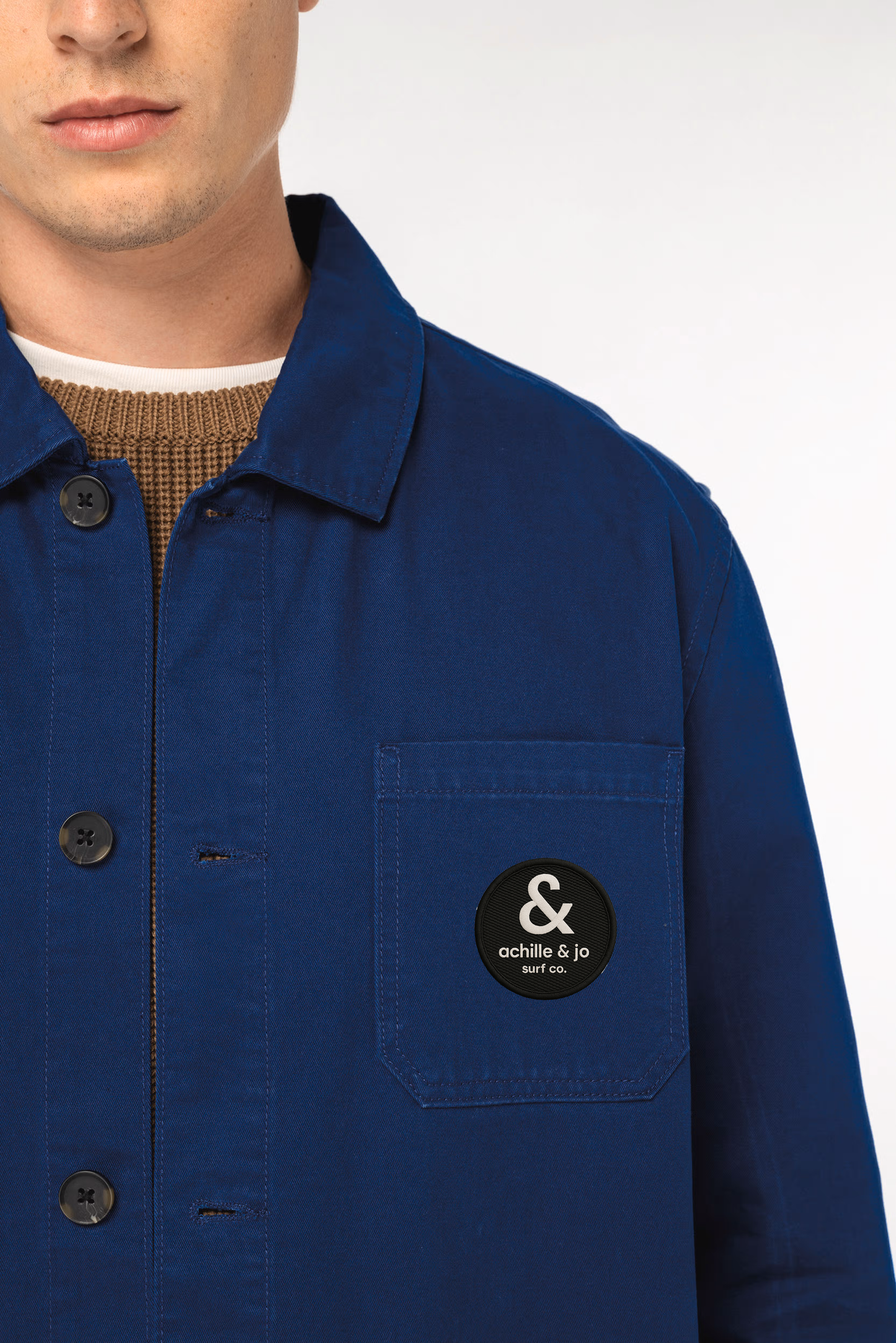 veste workwear bleue portée – gros plan avec patch brodé Achille & Jo